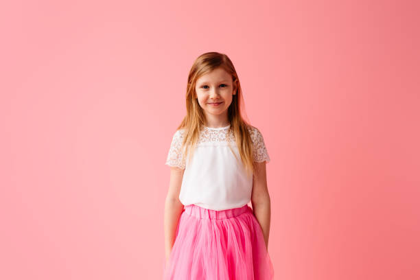 istock Happy smiling little girl on pink background in studio 1222464397