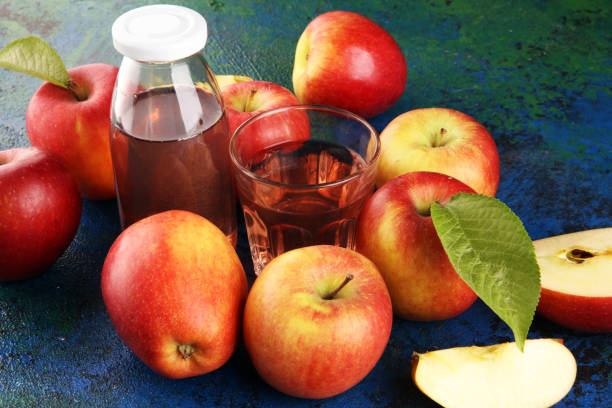 istock Apple cider drink and organic apples with leaves on table 1222465422