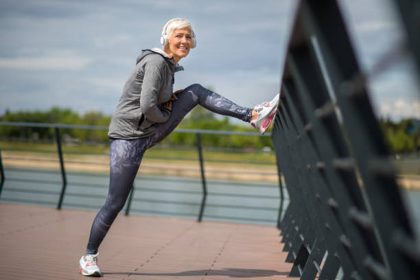 istock Active senior woman warming up by the river for jogging 1222466788