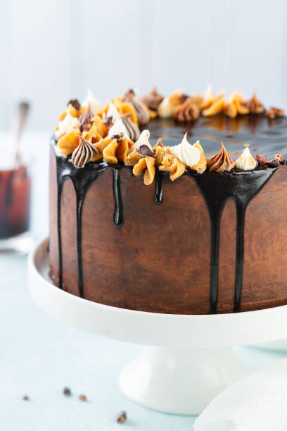 istock Dark Chocolate and peanut Cake with Chocolate Glaze ganache over light blue background. Copy space.. Sweet food. Sweet dessert. Trendy drip cake. 1222466804