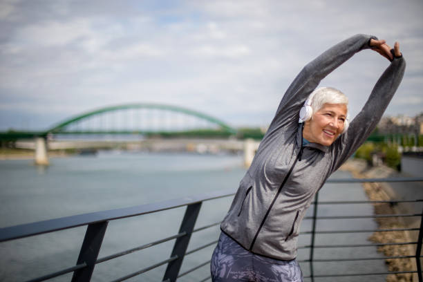 istock Active senior woman warming up by the river for jogging 1222466827