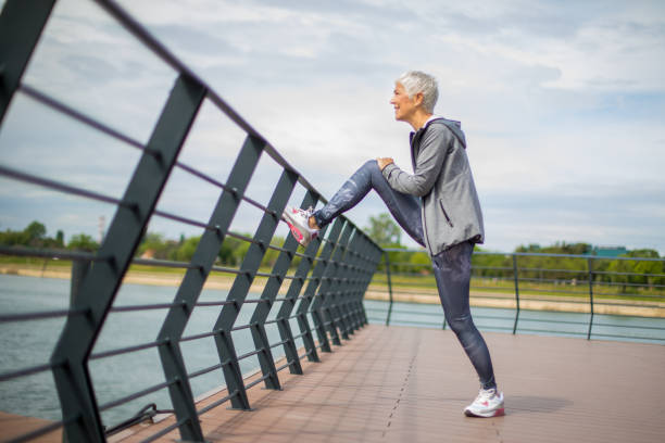 istock Active senior woman warming up by the river for jogging 1222466838
