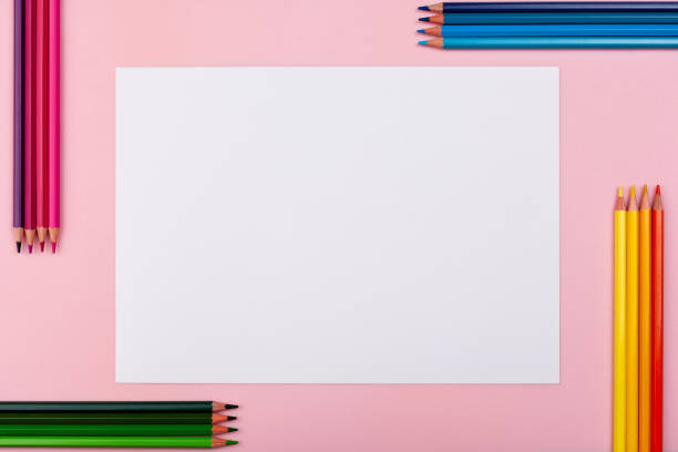 istock White sheet on a pink background. On each side are colored pencils. 1222467686