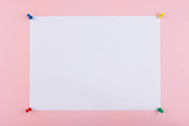 istock white sheet fastened with clerical multi-colored buttons on a pink background 1222467839