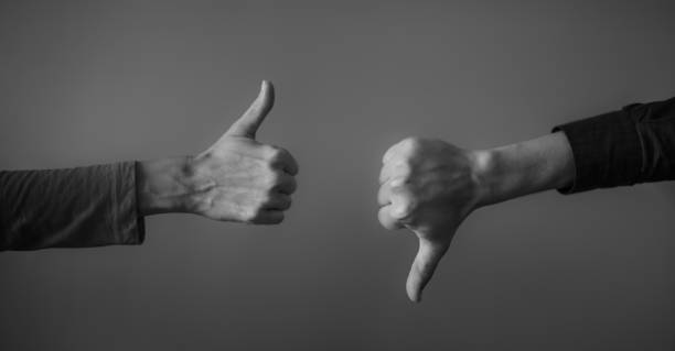 Thumbs up, thumbs down. Yes or no. Two people making hand sign thumbs up and thumbs down, yes or no, like or dislike concept. moving down photos stock pictures, royalty-free photos & images