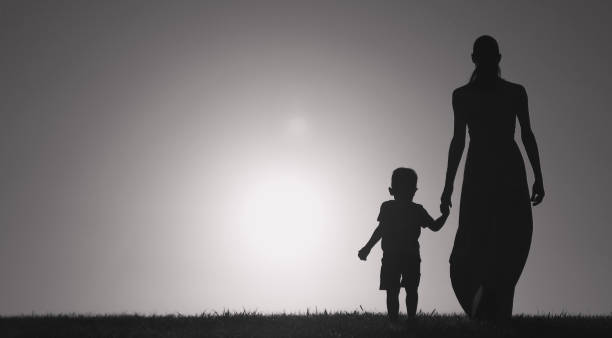 istock Mother son walking together outdoors holding hands. 1222468026
