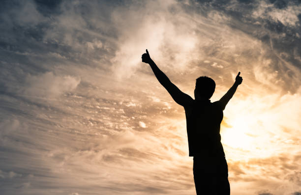 istock Happy man on sunset sky background with thumbs up feeling positive and energized. 1222468043