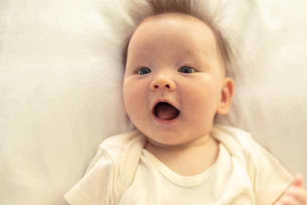 istock Happy smiling baby girl lying on bed. 1222468661