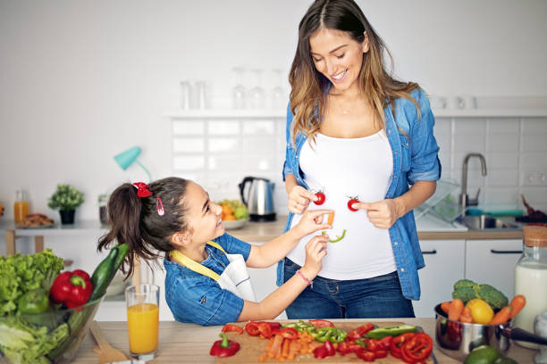 istock Pregnant mother is playing with her daughter in a kitchen 1222470573