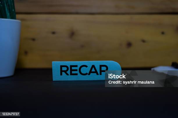 Recap Write On A Sticky Note Isolated On Wooden Background Stock Photo - Download Image Now