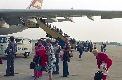 Düsseldorf, North Rhine-Westphalia, Germany, 1976. All-inclusive vacationers board a charter plane on the airfield of Düsseldorf Airport.
