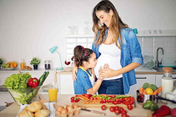 istock Pregnant mother is hugging her daughter in a kitchen 1222473687