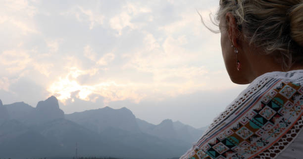 istock Woman looks towards mountain sunrise 1222476007