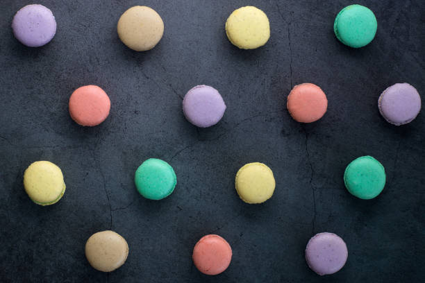 istock Colourful minimalistic greeting card concept. Different colours french macaroons on black grunge stone urban background. Poster for women, mom's day, wedding invitation, birthday, Copy space, flat lay 1222476663