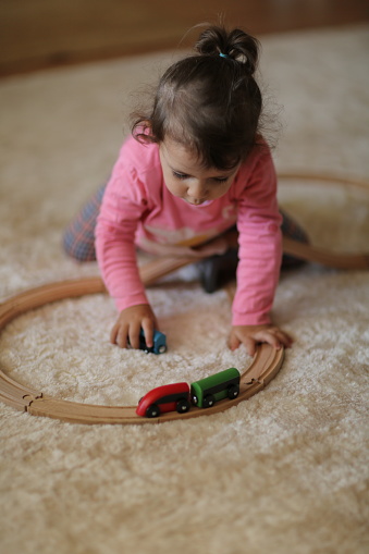 Linda niña jugando con tren de madera photo
