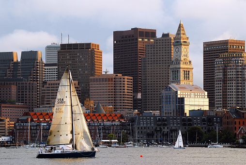 Boston, MA, USA August 10, 2011 A Sailboat regatta passes in front of the Custom House and the Boston Skyline