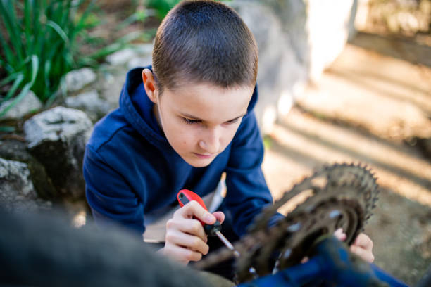 istock Boy in garden repairing bicycle 1222483698