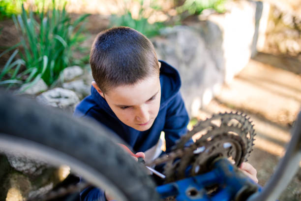 istock Boy in garden repairing bicycle 1222483754