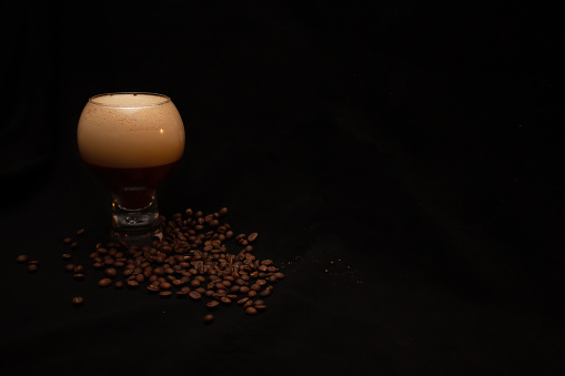 latte and coffee beans on black background