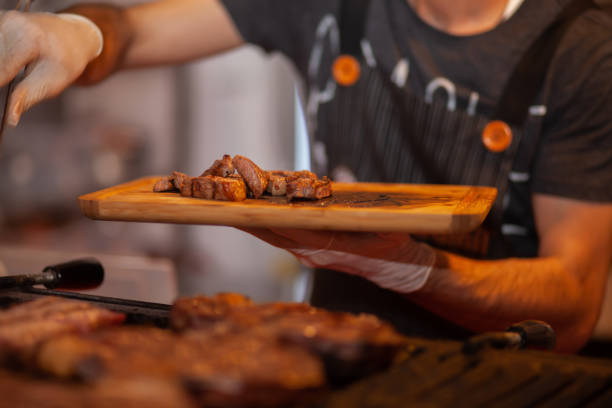 istock chef holding meat on wooden dish 1222494417