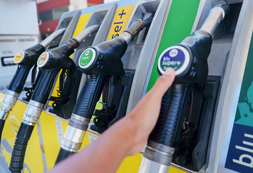 Diesel petrol fuel pistols nozzle refill at gas station. Fuel price crisis impact fuel cost in transport business and Travel energy consumption rise in petroleum gasoline station service production.