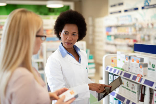 istock Pharmacist helping a costumer at Pharmacy. 1222500371