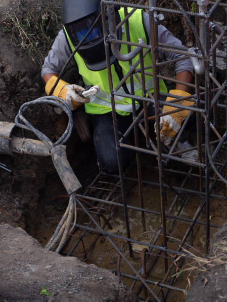 istock Worker in protective mask welding steel railings outdoors, sparks fly down 1222506952