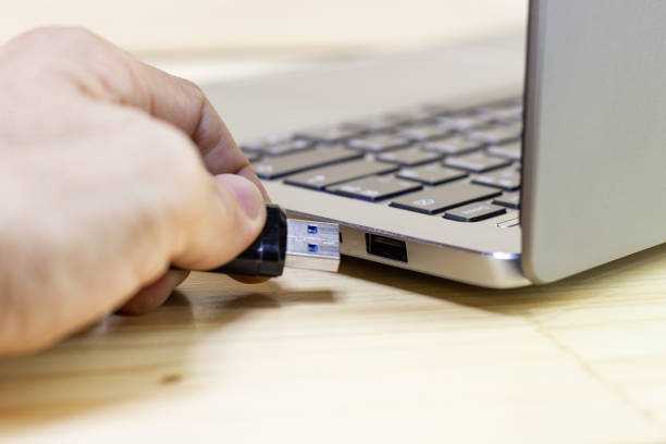 istock hand man hold Flash drive connect to USB port plug-in computer laptop for transfer data and backup business concept 1222516245
