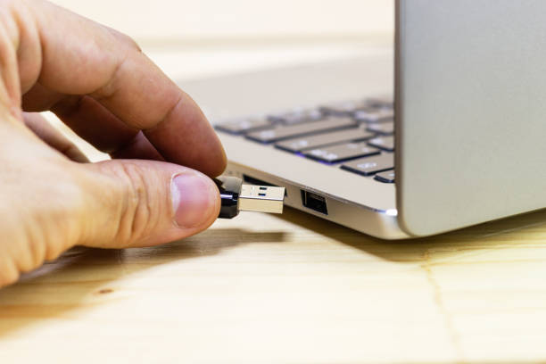 istock hand man hold Flash drive connect to USB port plug-in computer laptop for transfer data and backup business concept 1222516246