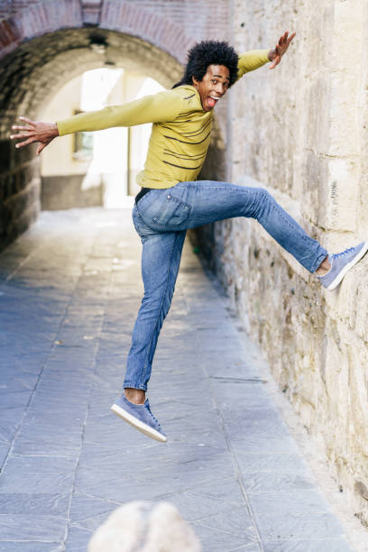istock Black man with afro hair jumping for joy 1222517436