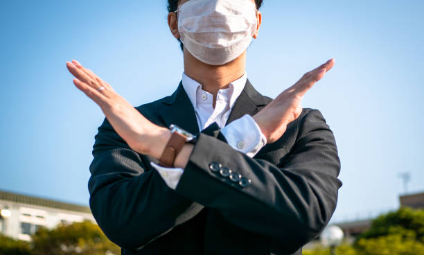 istock A businessman wearing a mask makes a NG gesture 1222519592
