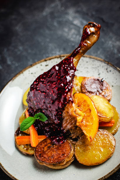 istock Whole Duck Roasted with Oranges, Carrots and Potatoes on Dark Stone Background 1222520575