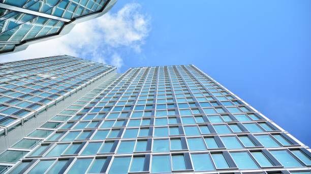 istock Structural glass wall reflecting blue sky. Abstract modern architecture fragment. 1222525545