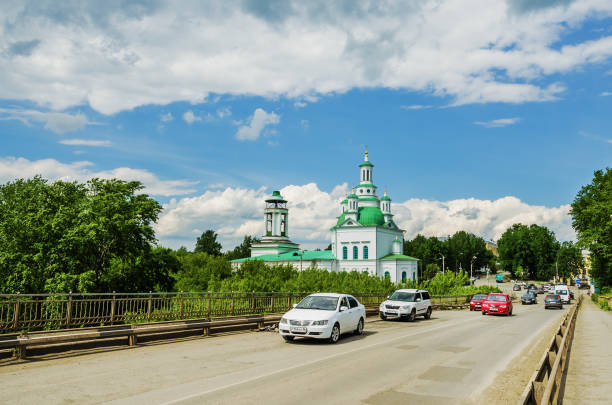 ALAPAYEVSK, RUSSIA - JUNE 15, 2017: View of the Holy Trinity Orthodox Cathedral  from the bridge over the river Alapaiha  in sunny summer day, Russia, Ural, Sverdlovsk Oblast.