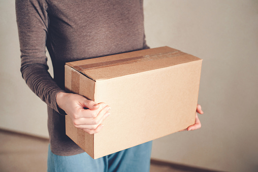Women's hands hold the box with the delivered order. The concept of delivery.