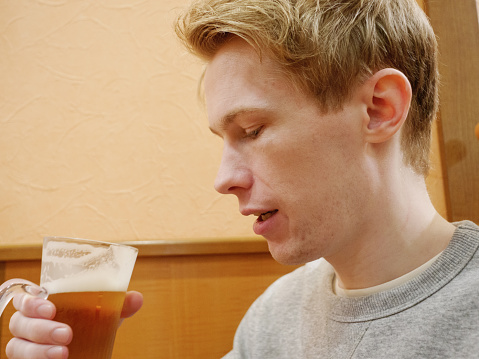 A handsome young man enjoying his beer.