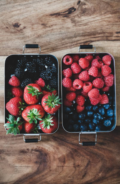 istock Fresh berries in metal lunchboxes over wooden background, copy space 1222536148