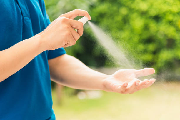 istock Asian delivery express courier young man use spray sterilize before giving boxes to woman customer receiving both protective face mask, under curfew quarantine pandemic coronavirus COVID-19 1222536452
