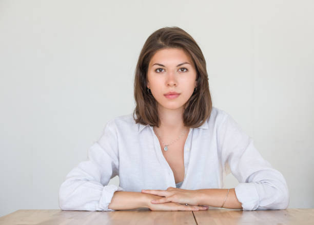 Portrait of a pretty young woman with dark hair on a neutral background. stock photo