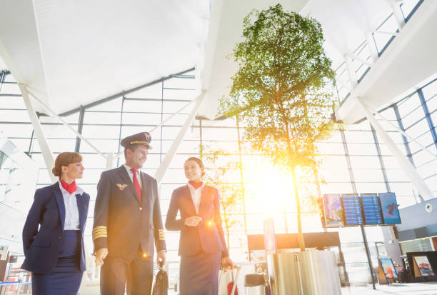istock Pilot with flight attendants walking in the airport 1222539749