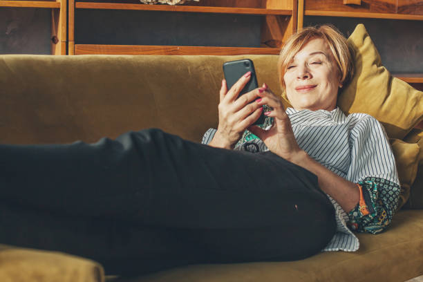 istock Senior lady with smart phone resting at home 1222541279