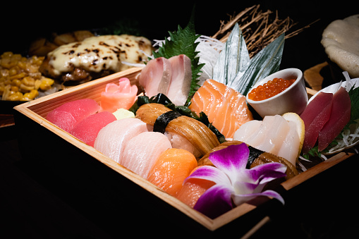 Japanese food, small cup of salmon egg, salmon, tuna and hotate. Japanese sea eel, wasabi and ginger.