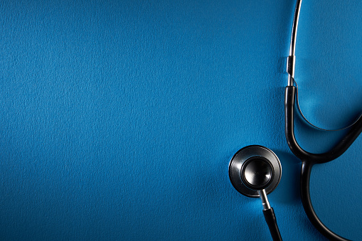 stethoscope on blue background with copy space