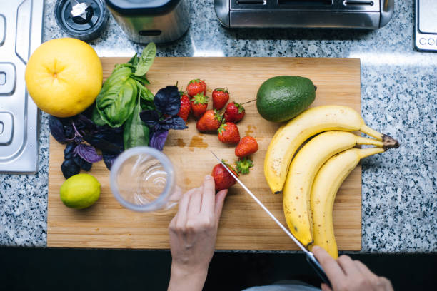 Woman making smoothie in kitchen