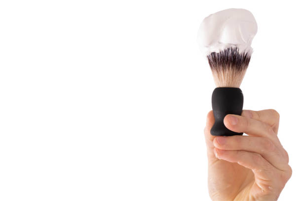 male hand holds a shaving brush on which foam on a white background