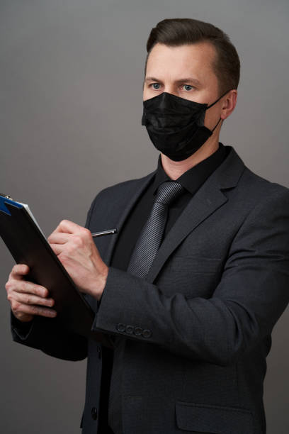istock Businessman Holding a Clipboard document. Coronavirus pandemic prevention concept 1222549269