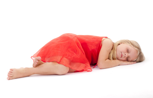 Little girl sleeping in a red dress on white background.