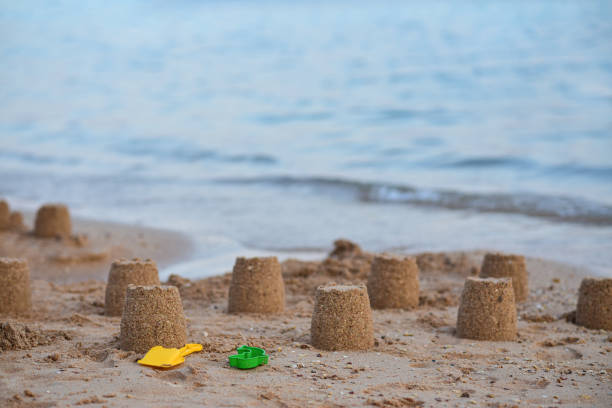 istock Children shovel with sand figures on a deserted beach 1222550972