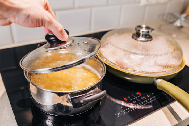 A man removes the lid from the pan