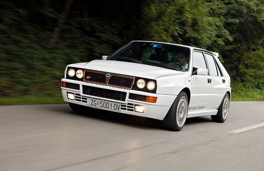 Zagreb, Croatia - September 18, 2009: Man is driving Lancia Delta HF Integrale Martini Racing Edition fast on a country road. This iconic Lancia model dominated the WRC scene in the '80s and '90s.